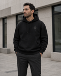 NORVEN Origin Essential Hoodie in black, styled with charcoal tailored trousers