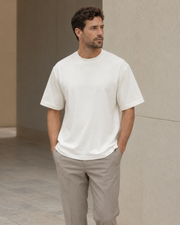 Man wearing the NORVEN Origin Heavyweight Tee in Warm White with tailored trousers