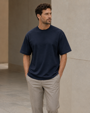 Man wearing the NORVEN Origin Heavyweight Tee in Deep Navy with tailored trousers